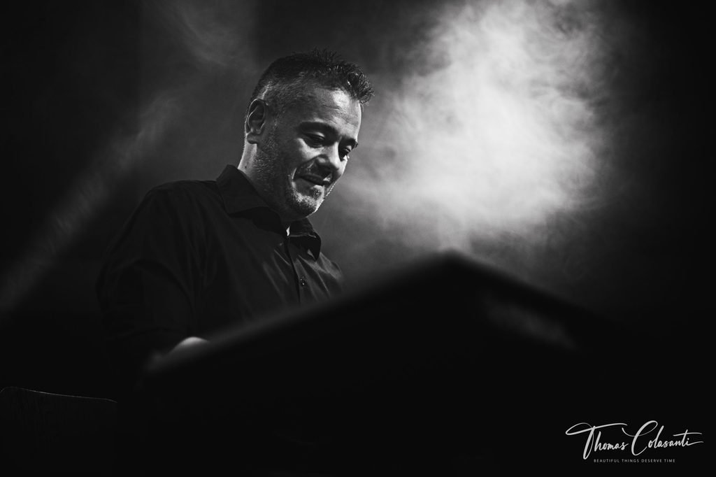 Manuele Montesanti playing keyboards under stage lighting